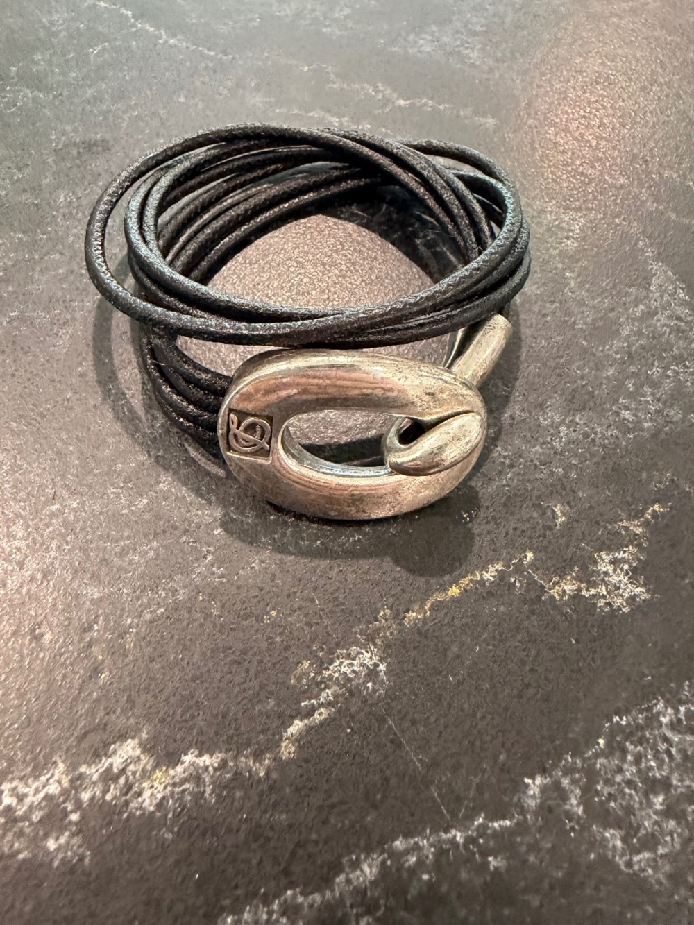 Multi strand black leather bracelet with silver plated logo clasp